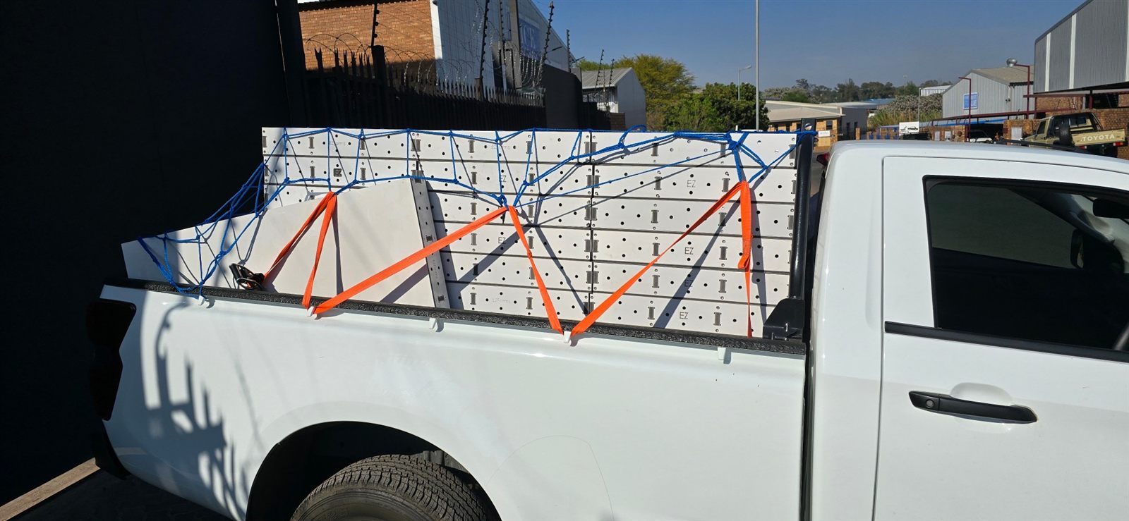 A bakkie loaded with a full set of EZForms panels, strapped and netted